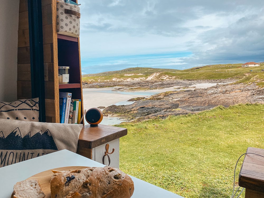 View over a beach from the back of a self converted campervan whilst wild camping on the Isle of Barra